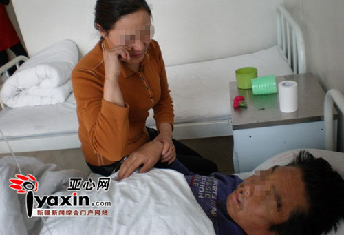 齐加军的妻子在病床前照顾他。 亚心网记者 胡大敏 摄