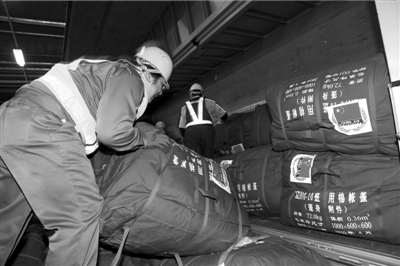 3月14日晚,东京羽田机场工作人员装卸中国首批对日地震援助物资