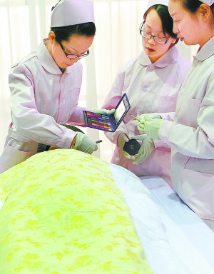 2010年11月28日,上海龙华殡仪馆的遗体整容师在为一名逝者化妆