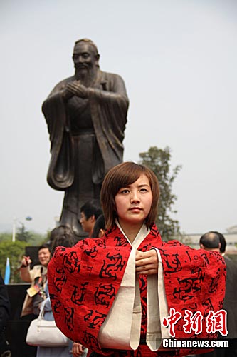 (连肖)着汉服,诵《论语》,行拜礼,10日,由中华儒商总会捐赠的孔子铜像