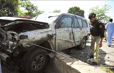 20日，巴基斯坦警方在现场查看被炸车辆。图/东方IC