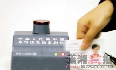  6月6日，高考工作人员对本次高考启用的身份证真伪鉴别仪进行示范操作。图/记者殷建军