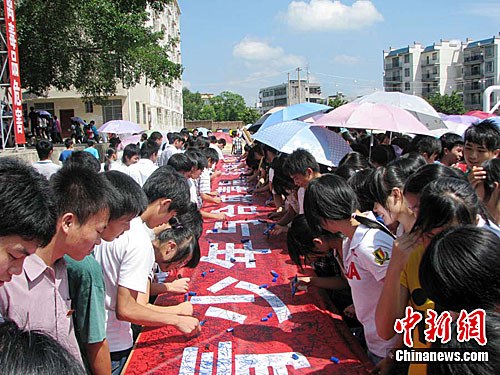 民警及中小学生纷纷在"参与禁毒斗争,构建和谐社会"的横幅上签名