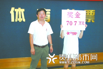 贵州省体彩中心副主任巴连利(左)给李小姐颁奖后合影。