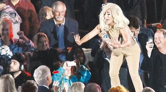 Lady Gaga受邀出席音乐会，以火辣装扮近距离为克林顿(箭头处)演唱。