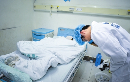眼角膜摘除后，医生向小男孩遗体致敬(图片来源：华西都市报)