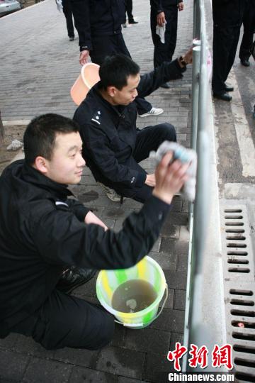 重庆市司法干警街头擦栏杆“学雷锋”。　连肖　摄