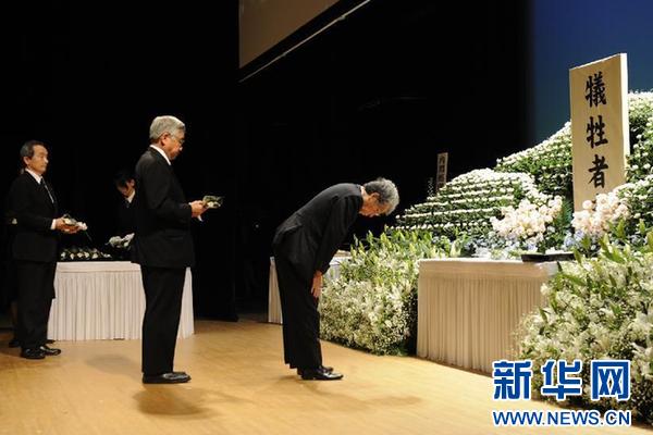 3月11日，在日本福岛县举行的“3·11”大地震一周年追悼仪式上，人们为死难者献花。新华社发（关贤一郎摄）