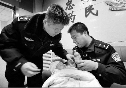 香河园派出所的邰政委（左一）和杨警长，正在给女婴喝奶 摄/记者郭谦