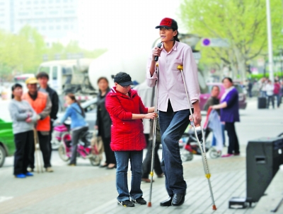 2米26小伙在女友帮助下街头卖唱。 贾晓宁 吴胜 摄
