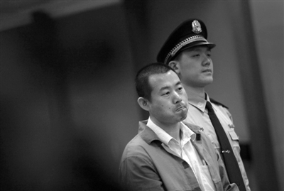 被告人王金生表情沉重。昨日，他因持棍打死父亲，涉嫌故意杀人在法庭受审。新京报记者 王贵彬 摄