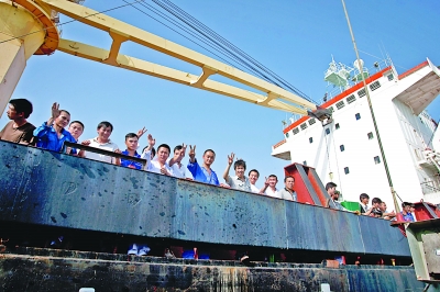 右图：“祥华门”号被救后，船员们在船上挥手致意。