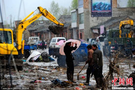 2012年5月13日，甘肃岷县，抢险救援工作仍在继续，安置点下起大雪。图为大型设备已经开始抢修。岩石 摄 CFP视觉中国