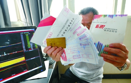 郑德益出示购买的股票软件和北京寄来的“至尊金卡”。记者 吴珊 摄