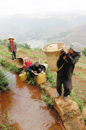 村民们把带来的水桶灌满水，小心翼翼地背下山。