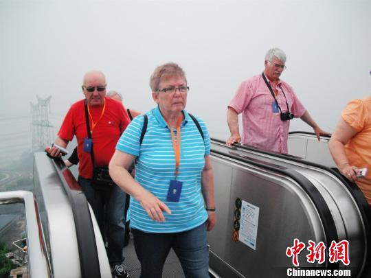 中外游客登乘电梯登顶坛子岭。高松摄