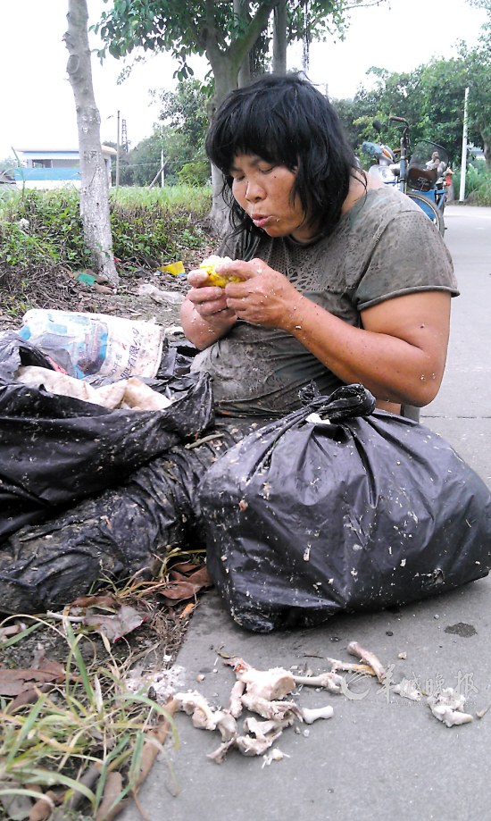 流浪女住垃圾站吃腐肉 发恶臭居民捂鼻而行(图)