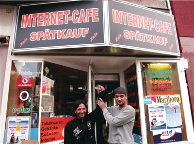 报警的网吧员工安拉伊什利 （左）在网吧门前留影。新华社发