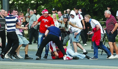 身着红色上衣的俄罗斯球迷被打倒在地。