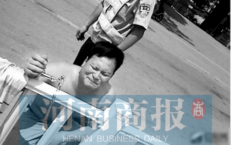 男子被铐在马路中间的护栏上