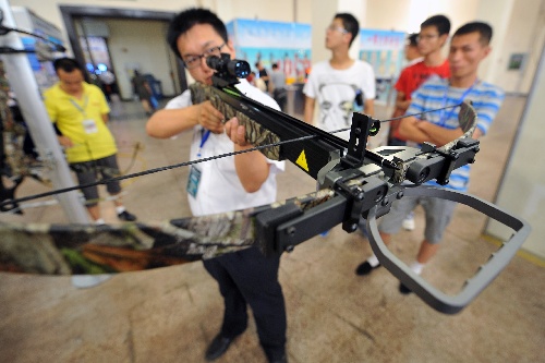 月19日,在山西安防科技产业博览会上,一位工作人员在展示军警专用弓弩