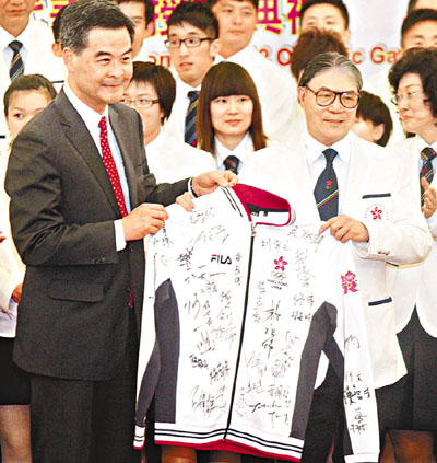 香港奥委会会长霍震霆向特首梁振英送上港队签名队服。 黄舒慧 摄