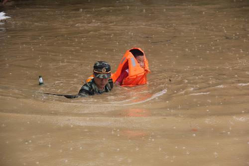 7月16日，消防官兵正在帮助一名儿童脱困。新华社发（柯友川 摄）