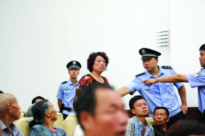 周龙斌当庭否认制造天湖爆炸案，引起受害人家属（左图）抗议，并与周龙斌家属在法庭上发生言语冲突。