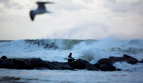 飓风“桑迪”即将登陆，一名男子在纽约趁势冲浪。（图片来源：CNN）