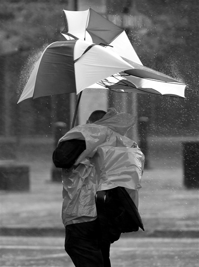 29日,马里兰州,一名行人撑着伞在风雨中行走