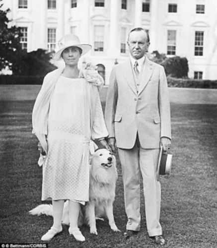 加尔文・库利奇和夫人在白宫草坪上和宠物狗在一起。
