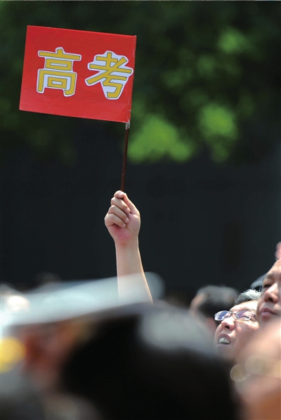6月7日，在东直门考点外，一名家长手举高考的小旗子迎接孩子。资料图片本报记者王苡萱摄