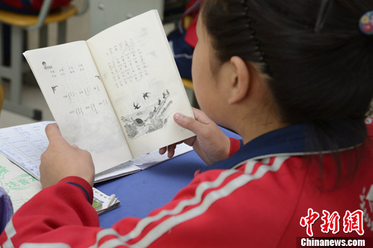 图为蒙古国小留学生正在阅读汉语课本。中新社发 刘文华 摄