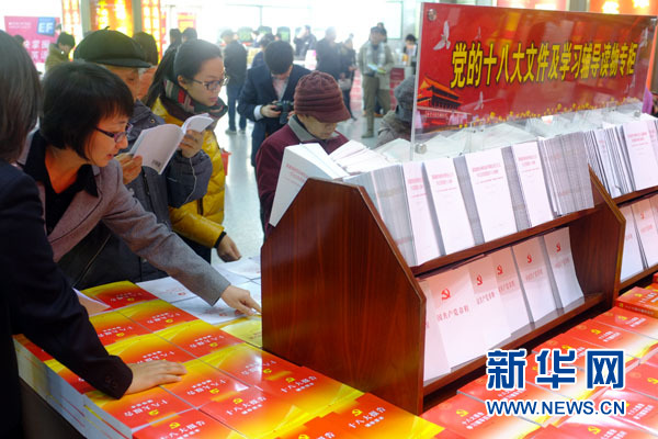 11月21日，读者在北京西单图书大厦“党的十八大文件及学习辅导读物专柜”选购图书。新华网记者 杨理光摄