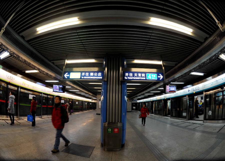 12月30日,两位市民在北京地铁6号线一期南锣鼓巷站内的壁画前留影