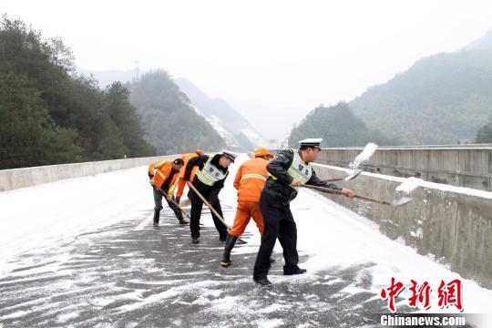 浙江台州高速交警支队四大队民警正铲除桥面积雪。 李巍 摄
