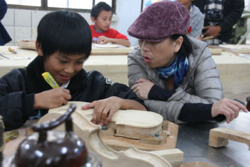 龙应台（右）赴南投县一小学聆赏原住民学童演奏交响乐。台湾 “中央社”