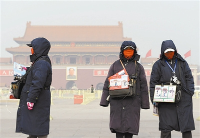 1月14日中午，北京天安门广场兜售交通地图的小贩全副武装。
