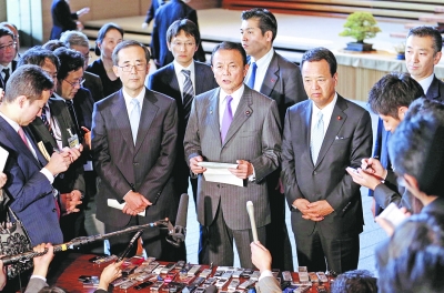 日本副首相麻生太郎（中）和日本央行行长白川方明（左）出席新闻发布会。