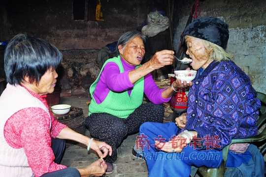 两个女儿在给彭阿婆喂粥。通讯员供图