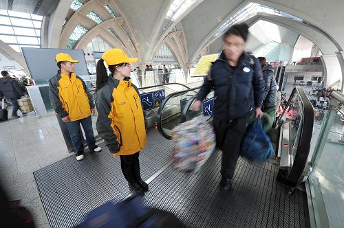 1月25日，在宁夏银川火车站，春运志愿者马应军和杨莉蓉（右）在引导旅客进入候车大厅。新华社记者 彭昭之 摄