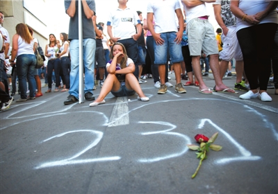 28日，在巴西南部城市圣玛丽亚，一名女孩坐在一个心形图案上方，图案内写着火灾事故死亡人数。新华社发