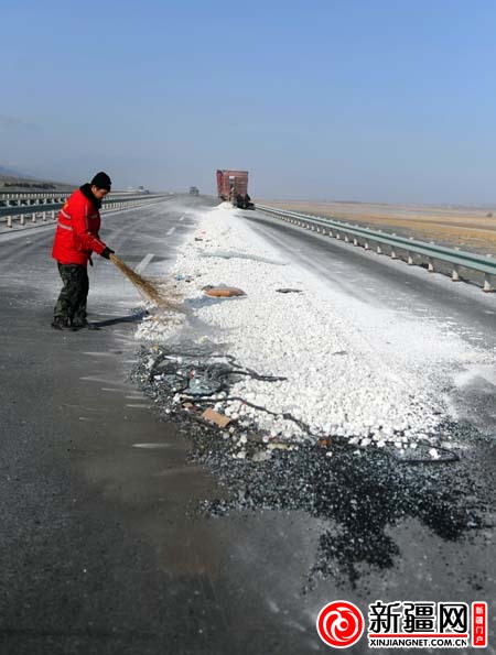 2月24日11时36分，在事故现场，高速公路工作人员正在清扫事发货车散落路面的石灰石。（本报记者魏向阳摄）