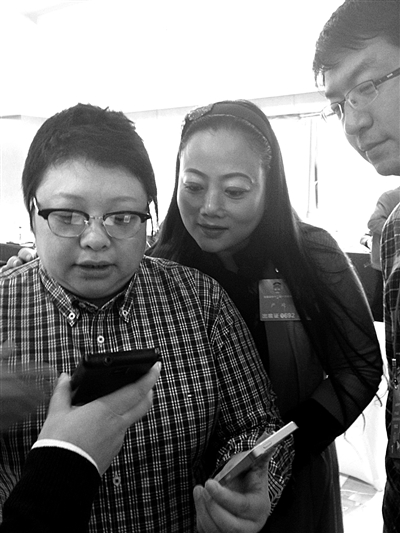 韩红和其他委员一起研究如何加微信好友，建公益群。新京报记者 魏铭言 摄