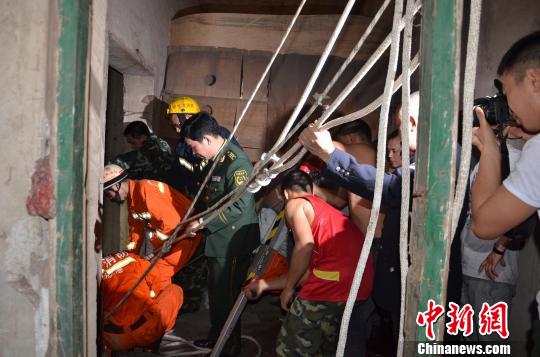 图为救援人员在废弃电梯井对坠楼妇女展开救助。 李琳莹 摄