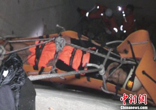 图为救援人员在废弃电梯井对坠楼妇女展开救助。 李琳莹 摄