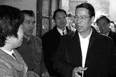 2002年，主政山东的张高丽（右）在东平县商老庄乡贫困户家中走访，为他们发放慰问金 资料照片 