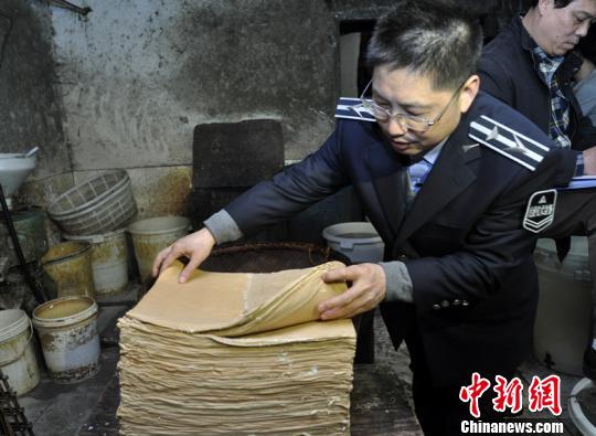执法人员登记清点生产的豆制品 朱敏 摄