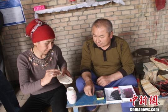 图为新疆岳普湖县居民苏拉依曼正在制作木排按摩拖鞋。 任丽瑛 摄