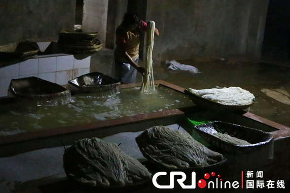 2013年4月9日，昆明，寻甸羊街一米线厂，工人正在清洗米线装筐。图片来源：CFP